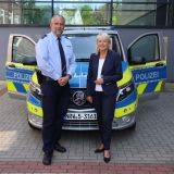 Polizeihauptkommissar Markus Häbel und Polizeipräsidentin Friederike Zurhausen stehen vor einem Streifenwagen mit geöffneten Türen