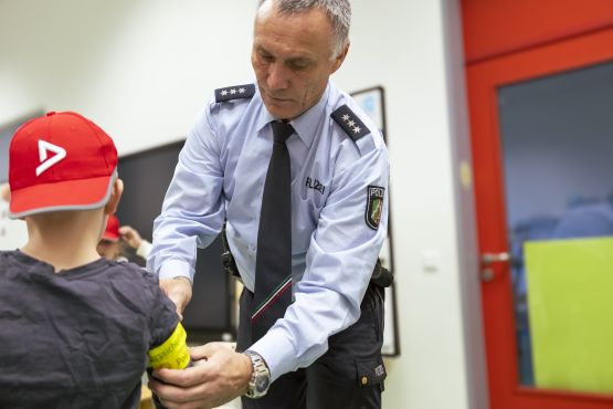 PHK Holger Siegburg erklärt den Kindern in Gladbeck, wie wichtig Sichtbarkeit im Straßenverkehr ist.