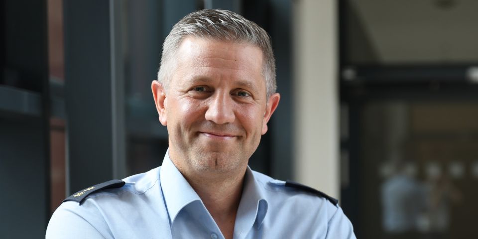 Thomas Franta im Portrait - er lächelt in die Kamera und trägt Uniform (Hemd)